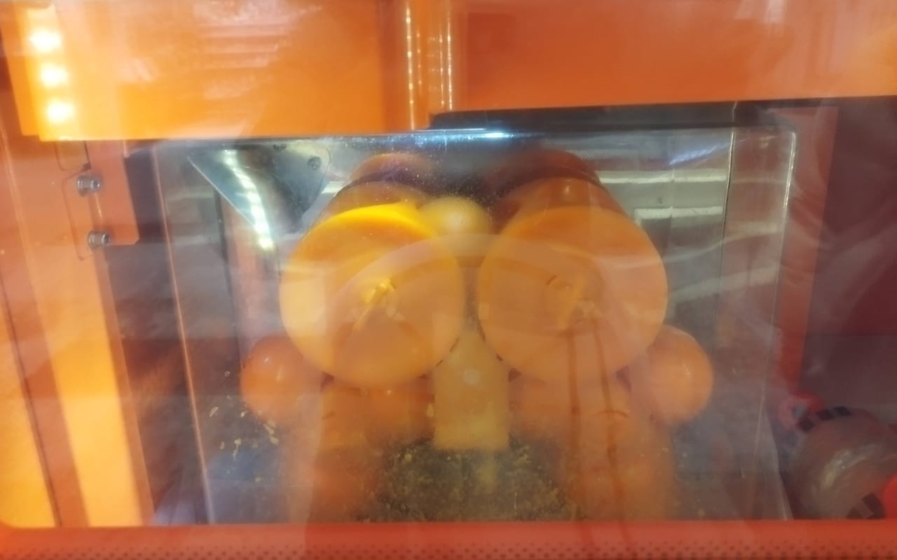 オレンジを機械で絞っているところ